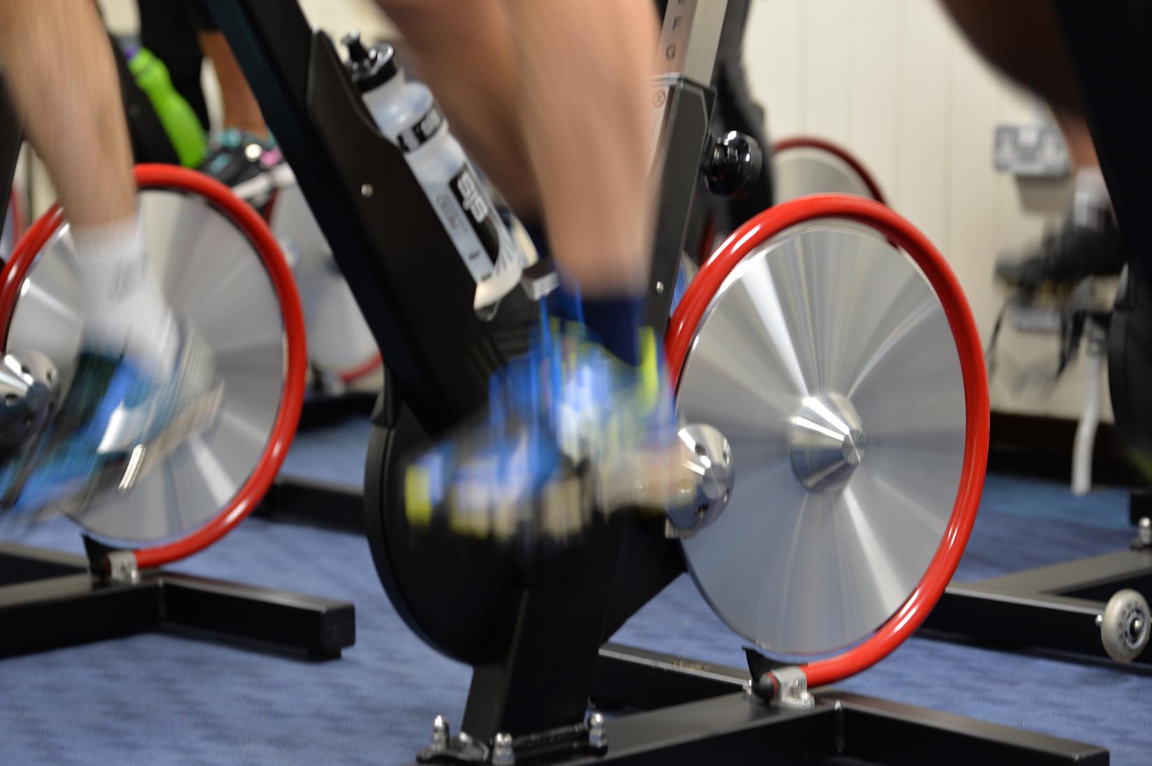 An exercise bike in use at the Sports Centre, legs and wheels blurred indicating movement