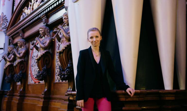 Anna Lapwood stands in front of an organ