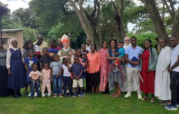 Abbot Robert stands with Oblates and their families in Zimbabwe