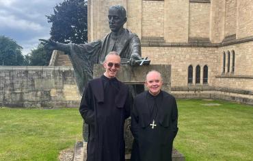 Abbot Robert and Prior stand before the St Benedict statue
